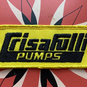May include: Yellow embroidered patch with black text that reads "Grisafuli Pumps".