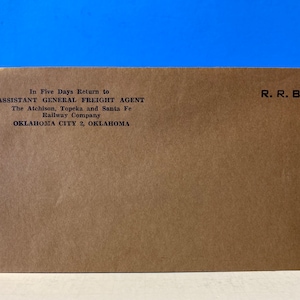 May include: A brown paper envelope with the text "In Five Days Return to ASSISTANT GENERAL FREIGHT AGENT The Atchison, Topeka and Santa Fe Railway Company OKLAHOMA CITY 2, OKLAHOMA R.R.B." printed on it.