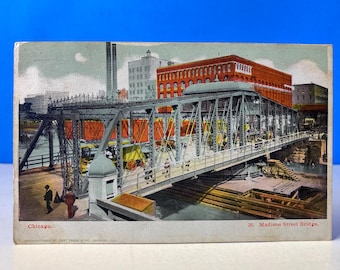 May include: Vintage postcard featuring the Madison Street Bridge in Chicago. The bridge is a steel truss structure with a pedestrian walkway, and is surrounded by buildings and other structures. The postcard has the text "Chicago" and "35. Madison Street Bridge."