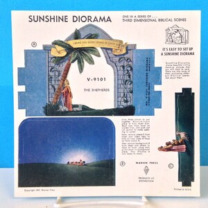 May include: A vintage paper diorama kit depicting a biblical scene with the text "I bring you good tidings of great joy" and "V-9101 The Shepherds". The diorama is titled "Sunshine Diorama" and is part of a series of third dimensional biblical scenes.