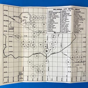 Puede incluir: Un mapa en blanco y negro de Oklahoma City, Oklahoma, que muestra las áreas comerciales y sus ubicaciones. El mapa está dividido en una cuadrícula con cuadrados numerados. El mapa también incluye una estrella que marca la ubicación de Oklahoma City.
