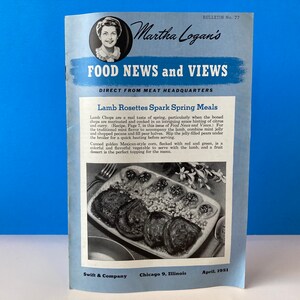 Puede incluir: Una portada de libro de cocina vintage con una mujer sonriente, titulada "Martha Logan's Food News and Views: Direct from Meat Headquarters". La portada también presenta una receta para "Lamb Rosettes Spark Spring Meals" con una foto de un plato de rosetas de cordero con un acompañamiento de judías verdes y pimientos rojos.