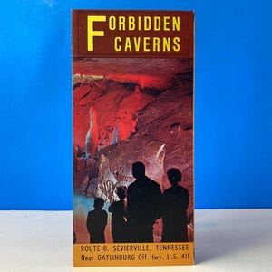 May include: A vintage brochure for Forbidden Caverns in Sevierville, Tennessee. The cover features a red-lit cave scene with silhouetted figures. The brochure's title is in yellow letters on a brown background.