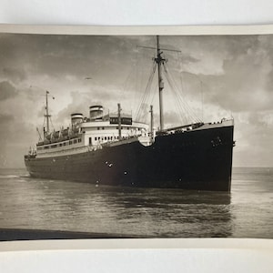 May include: Black and white vintage photograph of a large passenger ship sailing on the water.
