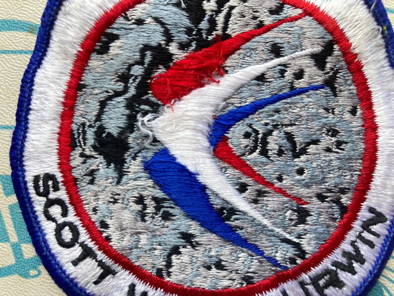 Peut inclure: Un &eacute;cusson brod&eacute; blanc, rouge et bleu avec le texte "Scott Air Force Base" en lettres noires.