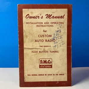 May include: A vintage owner's manual for a Custom Auto Radio with push button tuning. The manual is printed on a tan paper with a red border and features the Ford Motor Company logo. The manual is titled "Owner's Manual" and includes the model number FAC-18805-B.