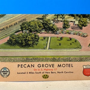 May include: Aerial view of the Pecan Grove Motel, located on US Highway 17, 5 miles south of New Bern, North Carolina. The motel is surrounded by trees and grass, and has a "Courtesy Court" designation. It is officially approved by the Ocean Highway Association.