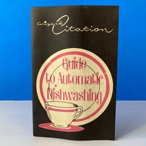 May include: A black and white guide to automatic dishwashing with a pink and white illustration of a teacup and saucer. The guide is titled "Wizard Citation Guide to Automatic Dishwashing".