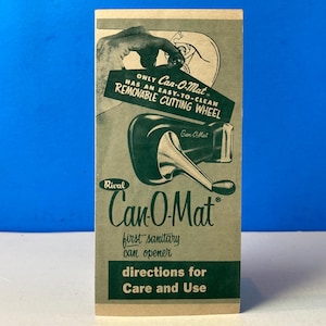 May include: Vintage Can-O-Mat can opener packaging. The green and white packaging features the product name, a graphic of the can opener, and the text "first sanitary can opener." The packaging also states the can opener has a removable cutting wheel.