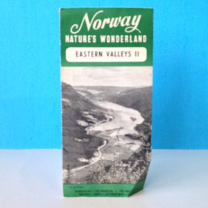 May include: A vintage travel brochure for Norway, featuring the text "Norway Nature's Wonderland Eastern Valleys II" and a black and white photo of a river winding through a valley.
