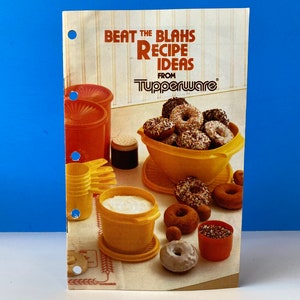 Könnte beinhalten: Ein Vintage-Tupperware-Rezeptheft mit dem Titel "Beat the Blahs Recipe Ideas" mit Bildern von Donuts und verschiedenen Tupperware-Behältern. Das Heft ist orange, gelb und weiß, mit blauem Hintergrund.