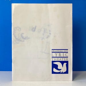 Puede incluir: Un folleto blanco con texto azul que dice "Oklahoma City Lyric Theater" y un logotipo de paloma azul.