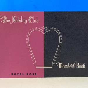 Op de afbeelding: Een bordeauxrood en zwart boekje met een wit gestileerd hartontwerp en de tekst "The Nobility Club" en "Members Book". De onderkant van het boekje heeft de tekst "Royal Rose".