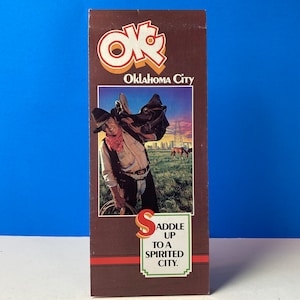Puede incluir: Un folleto de viaje vintage para Oklahoma City con un vaquero a caballo frente a un horizonte urbano. El texto dice "OKC Oklahoma City Saddle Up To A Spirited City."