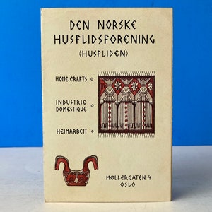 Könnte beinhalten: Eine cremefarbene Vintage-Karte mit dem Text "DEN NORSKE HUSFLIDSFORENING (HUSFLIDEN)". Sie zeigt Illustrationen eines Teppichs, eines dekorativen Objekts und die Wörter "HOME CRAFTS", "INDUSTRIE DOMESTIQUE" und "HEIMARBEIT". Die Adresse "MØLLERGATEN 4 OSLO" ist ebenfalls aufgedruckt.