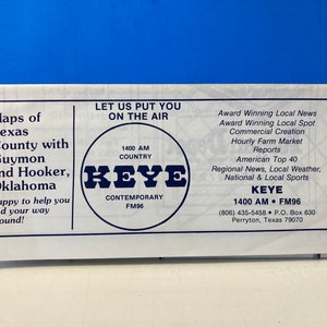 Può includere: Un opuscolo bianco e blu con il testo "Maps of Texas County with Guymon and Hooker, Oklahoma" e "KEYE 1400 AM COUNTRY CONTEMPORARY FM96". Il opuscolo pubblicizza una stazione radio con informazioni sulla programmazione della stazione e le informazioni di contatto.