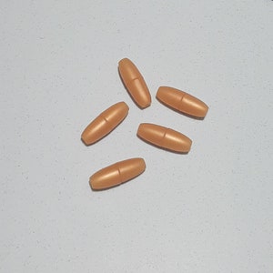May include: Five brown plastic cord end stoppers. The stoppers are oval shaped and have a smooth, glossy finish.