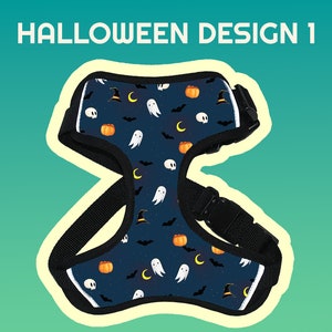 May include: A black dog harness with a Halloween-themed design. The harness features a blue background with orange pumpkins, white ghosts, black bats, and crescent moons.