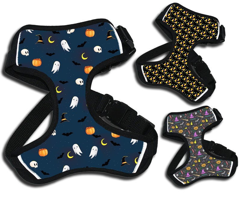 May include: Three different Halloween-themed dog harnesses. The first harness is blue with a pattern of ghosts, pumpkins, bats, and witch hats. The second harness is black with a pattern of orange and yellow candy corn. The third harness is black with a pattern of purple, orange, and green Halloween-themed icons.