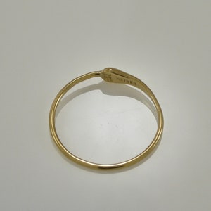 Puede incluir: Un anillo de oro con un dise&ntilde;o sencillo. El anillo est&aacute; marcado con el texto "K18" en el interior.