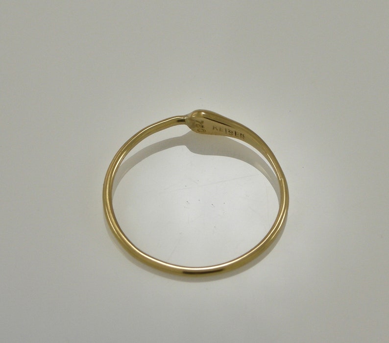 Puede incluir: Un anillo de oro con un dise&ntilde;o sencillo. El anillo est&aacute; marcado con el texto "K18" en el interior.