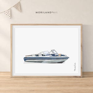 Peut inclure: Une impression d'art encadrée représentant un bateau à moteur bleu et blanc avec un petit chien assis dans le cockpit. Le texte MORILAND Art est imprimé en haut au centre, et la signature Meriah Landon est imprimée verticalement en bas à droite.