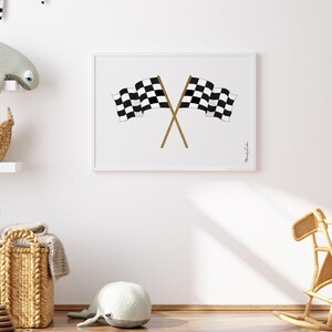 May include: A black and white checkered racing flag print with gold crossed sticks in a white frame. The print is hanging on a white wall.