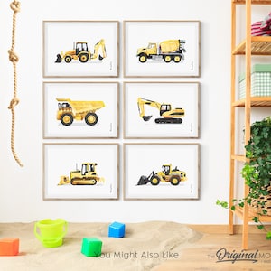 May include: Six framed prints of yellow construction vehicles, including a bulldozer, excavator, dump truck, and cement mixer. The prints are displayed on a white wall with a rope hanging on the left side. The prints are in a nursery or playroom setting.