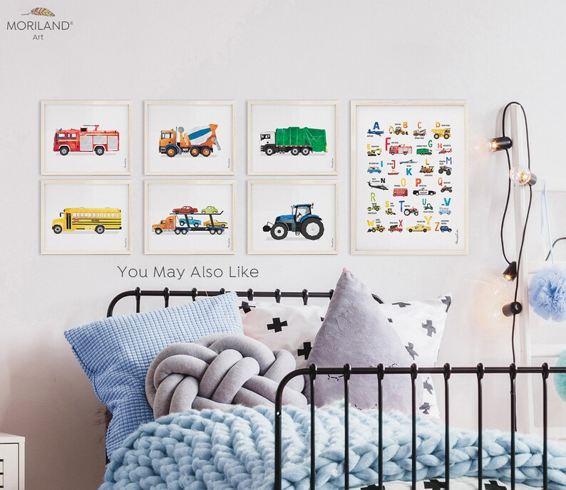May include: A set of six framed prints featuring colorful illustrations of different vehicles, including a fire truck, a cement mixer, a garbage truck, a school bus, a car carrier, and a tractor. The prints are arranged in a grid pattern on a white wall. The text "You May Also Like" is visible below the prints.