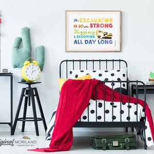 Op de afbeelding: Een zwart metalen bedframe met een wit en zwart gestippeld dekbedovertrek en een rode deken. Een gele wekker staat op een zwarte kruk naast een groen cactus kussen. Een ingelijst print met de tekst "The Excavator is so strong Digging & Scooping All Day Long" hangt aan de muur.