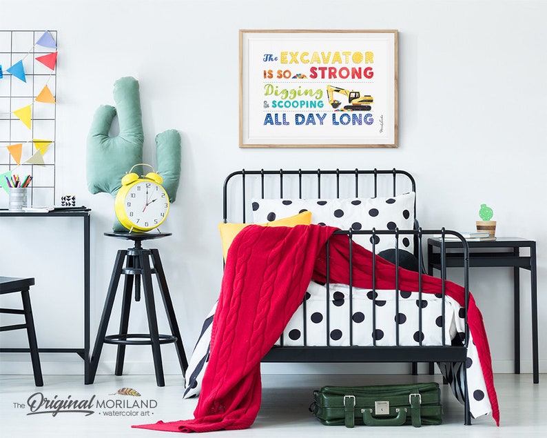 Op de afbeelding: Een zwart metalen bedframe met een wit en zwart gestippeld dekbedovertrek en een rode deken. Een gele wekker staat op een zwarte kruk naast een groen cactus kussen. Een ingelijst print met de tekst "The Excavator is so strong Digging & Scooping All Day Long" hangt aan de muur.