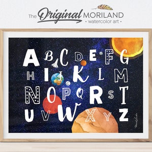 May include: A colorful alphabet poster with a space theme. The letters are white with black outlines and are surrounded by planets, stars, and a rocket ship. The background is a dark blue with white stars.