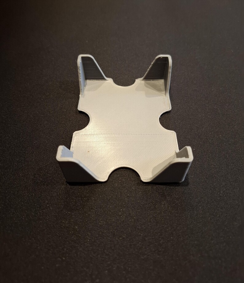 K&ouml;nnte beinhalten: Ein wei&szlig;er Plastik-Kartenhalter mit zwei Steckpl&auml;tzen zum Aufbewahren von Karten. Der Halter ist so konzipiert, dass er aufrecht steht.