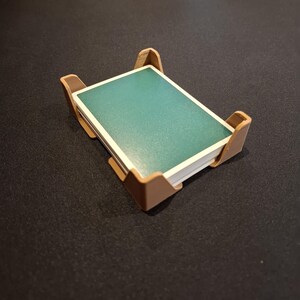 K&ouml;nnte beinhalten: Ein brauner Plastikkartenhalter mit einem Stapel t&uuml;rkisfarbener Spielkarten darin.