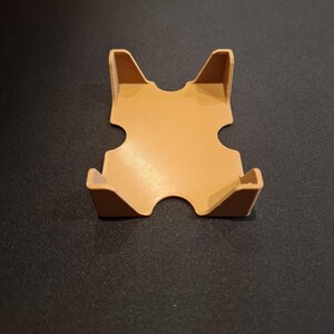 K&ouml;nnte beinhalten: Ein brauner Plastikkartenhalter mit vier Seiten und einer quadratischen Basis. Der Halter hat an jeder Seite zwei Aussparungen, um Karten zu halten.