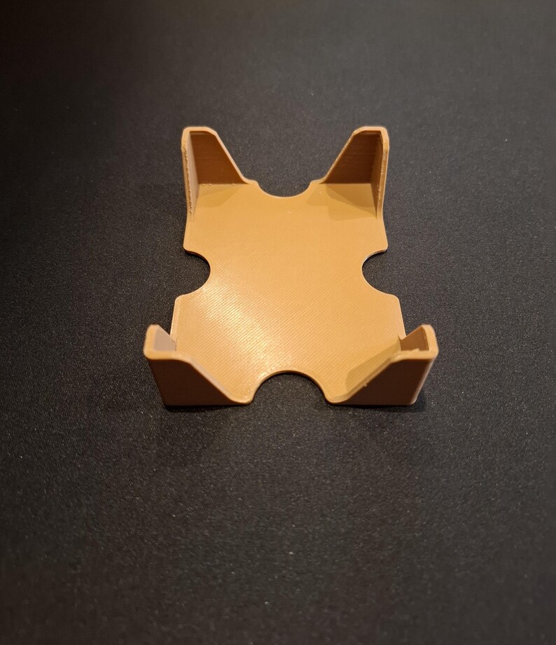 K&ouml;nnte beinhalten: Ein brauner Plastikkartenhalter mit vier Seiten und einer quadratischen Basis. Der Halter hat an jeder Seite zwei Aussparungen, um Karten zu halten.