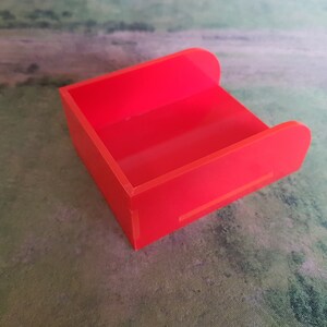 K&ouml;nnte beinhalten: Eine leuchtend rote Plastik-Aufbewahrungsbox mit rechteckiger Form und abgerundeten Kanten.