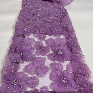 May include: Purple beaded lace fabric with 3D floral appliques. The fabric has a sheer, delicate texture and is adorned with small, pearl-like beads.
