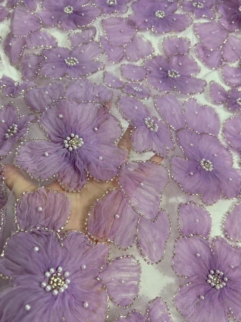 May include: Purple floral lace fabric with 3D flowers and pearl embellishments.