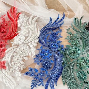 以下が含まれることがあります： ビーズの装飾が施された刺繍レースのトリムが4種類。トリムは赤、白、青、緑です。