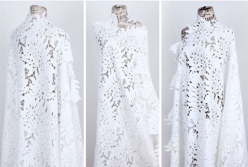 May include: White lace fabric with a floral pattern. The fabric is delicate and has a soft texture.