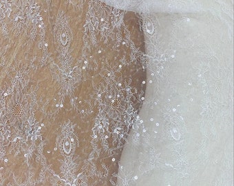 Renda Chantilly francesa branca e marfim com lantejoulas, ideal para vestidos de noiva, damas de honra e véus. Renda floral bordada vendida por metro.