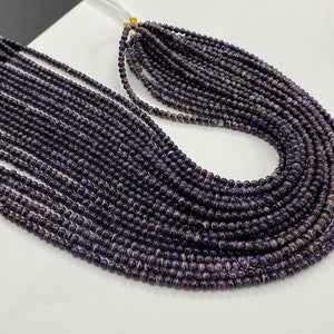 Peut inclure: Un brin de perles rondes rayées de couleur violet foncé et blanc. Les perles sont enfilées sur un fil blanc et mesurent environ 4 mm de diamètre.
