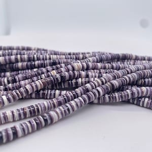 May include: A strand of purple and white shell beads. The beads are round and have a striped pattern.