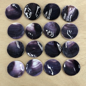May include: A collection of 15 round, purple and white shell pendants. The shells have a natural, organic pattern and are perfect for jewellery making.