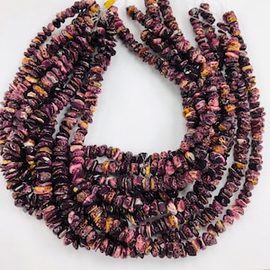May include: A strand of purple and brown lava rock beads. The beads are irregular in shape and have a rough, textured surface.