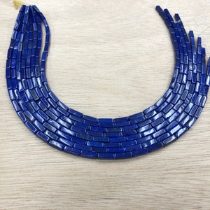 May include: A strand of dark blue lapis lazuli beads, each bead is rectangular in shape.