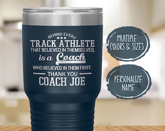 May include: A navy blue stainless steel tumbler with a silver lid. The tumbler has an inscription that reads "Behind every track athlete that believed in themselves, is a coach who believed in them first. Thank you Coach Joe".