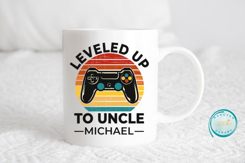 May include: White ceramic mug with a retro-style graphic of a video game controller and the text "LEVELED UP TO UNCLE -MICHAEL-"