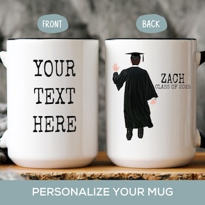 May include: White ceramic coffee mug with a black handle. The front of the mug says "YOUR TEXT HERE". The back of the mug has a black and white illustration of a person wearing a graduation cap and gown. The text on the back says "Zach Class of 2025".